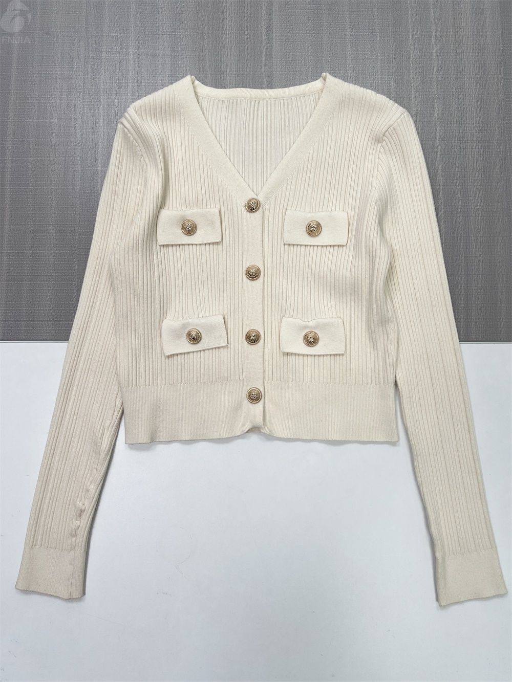 Женский укороченный кардиган из трикотажа в рубчик цвета слоновой кости с пуговицами и карманами, украшенными золотом