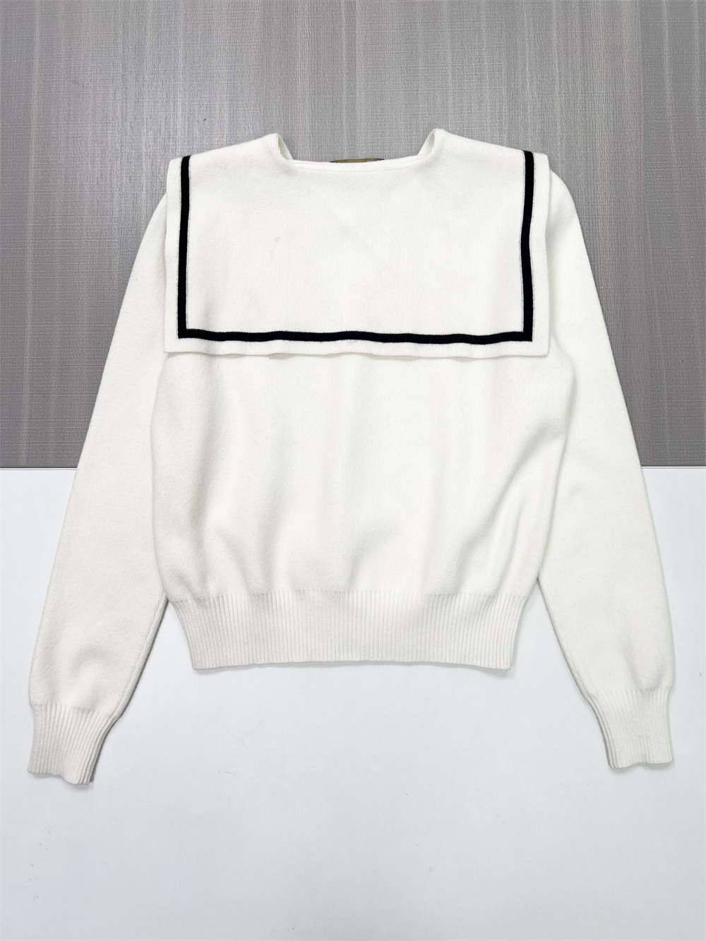 Женский вязаный свитер с белым матросским воротником и контрастной отделкой и эмблемой