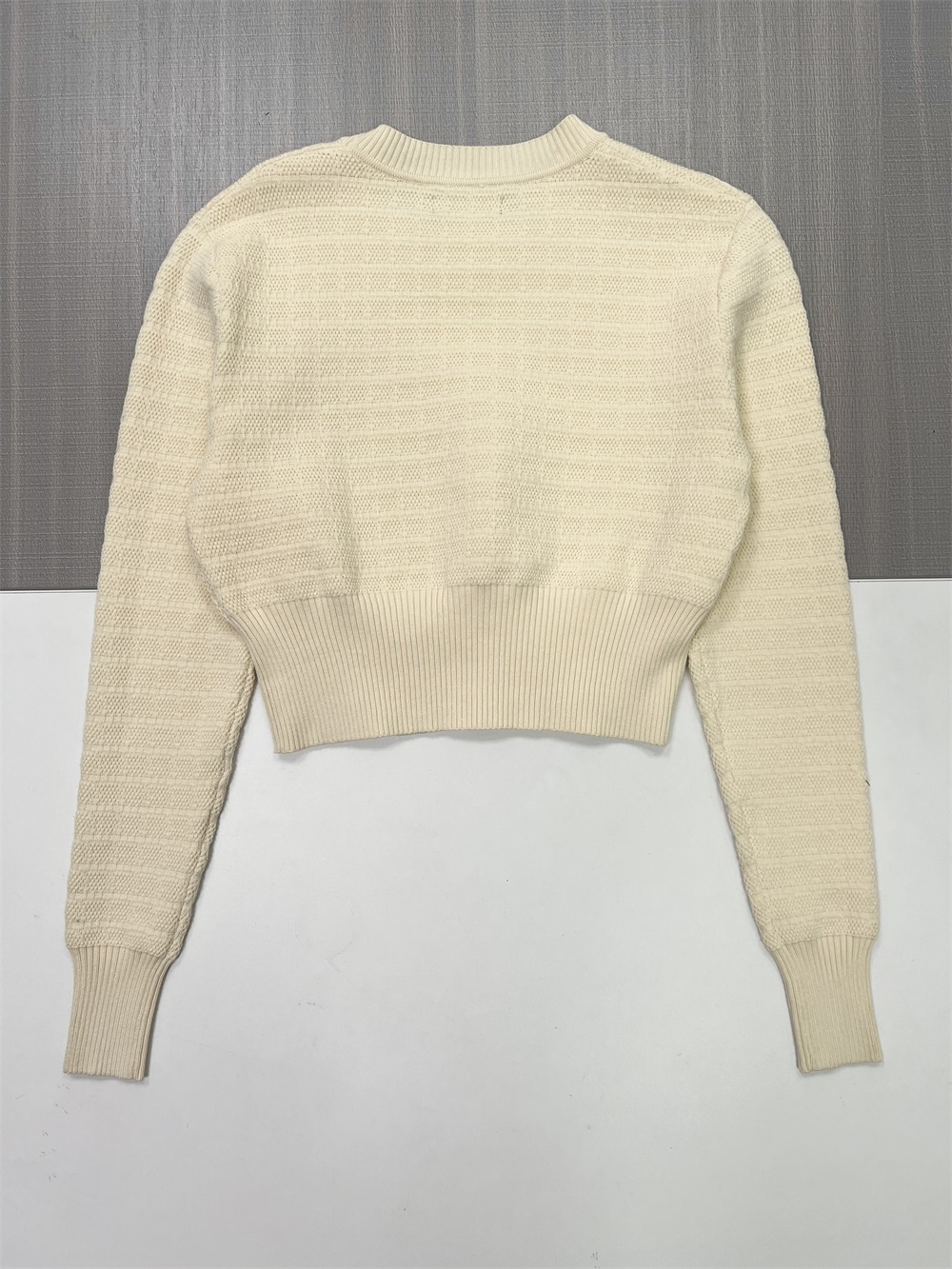 Женский свитер фактурной вязки цвета слоновой кости (укороченный крой, боковые пуговицы и круглый вырез)